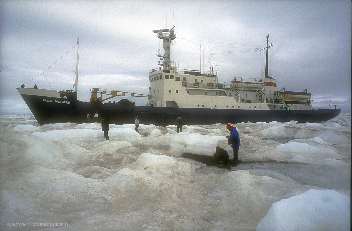 73 SIBERIA.jpg - Luglio/Agosto 1992. Siberia, terra dei Chukchi. Nell'oceano artico  125 Km a nord-est della penisola dei Chukchi (Siberia) c'Ã¨ l'isola di Wrangel, essa ospita piÃ¹ del doppio di specie vegetali (417) di qualsiasi territorio artico a paritÃ  di superficie nonchÃ¨ 30 specie diverse di uccelli oltre ad orsi polari, foche e trichechi ; per questo motivo   Ã¨ stata proclamata patrimonio dell'umanitÃ  dall'UNESCO. Nella foto la nave non puÃ² piÃ¹ procedere stretta nella morsa del ghiaccio si Ã¨ in attesa di un elicottero militare che atterrando sul ghiaccio della banchisa ci preleverÃ  per portarci a destinazione.